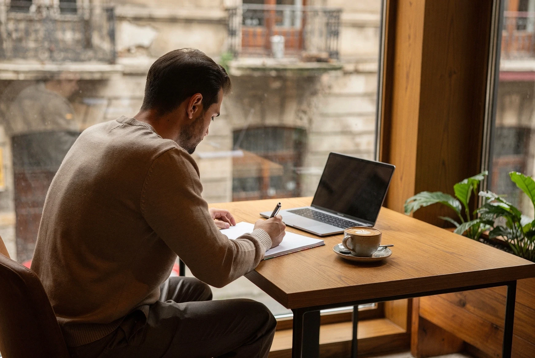 Founder planning business finances in a Tbilisi cafe with notebook and coffee