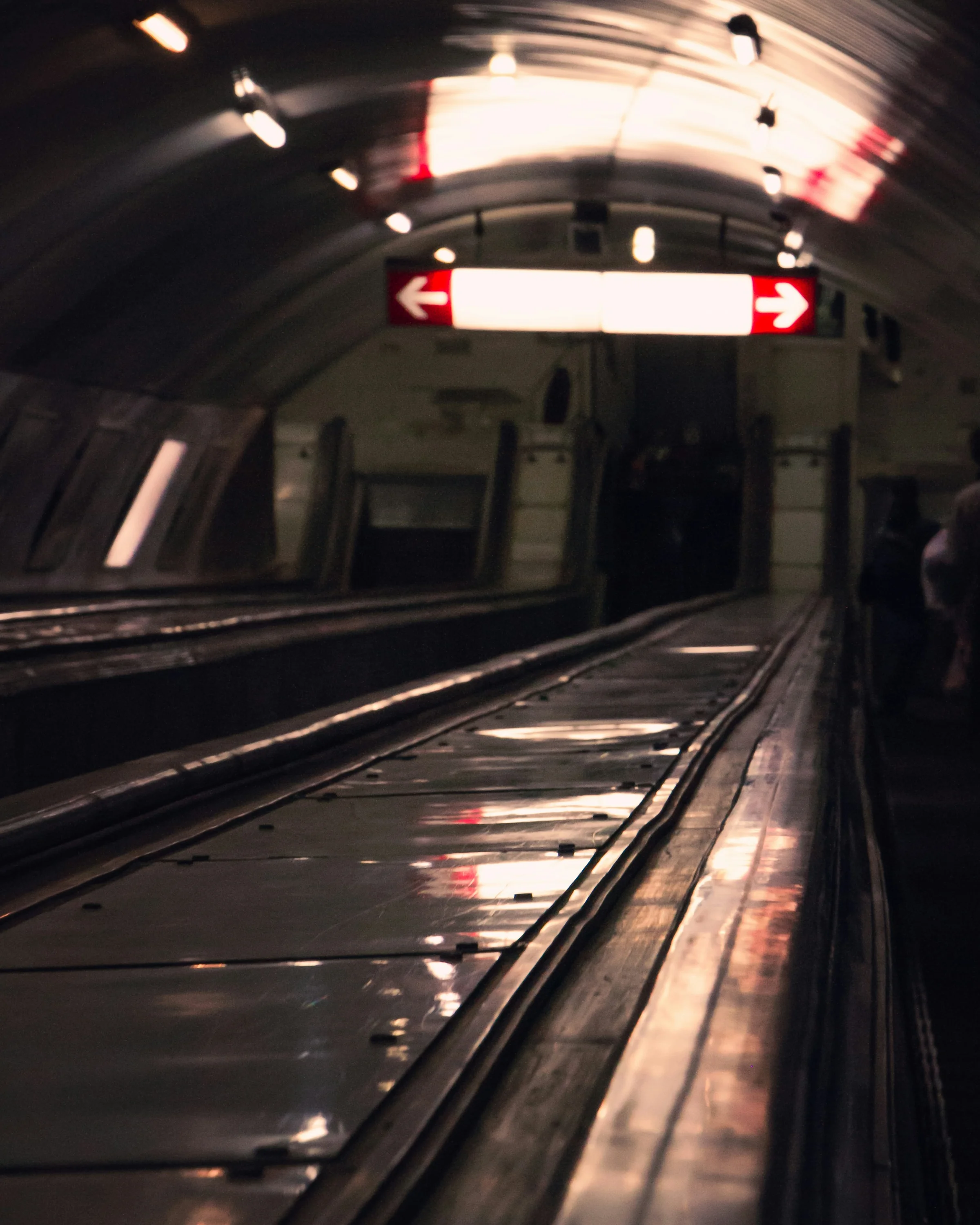 Tbilisi metro station escalator with directional signs and moody lighting