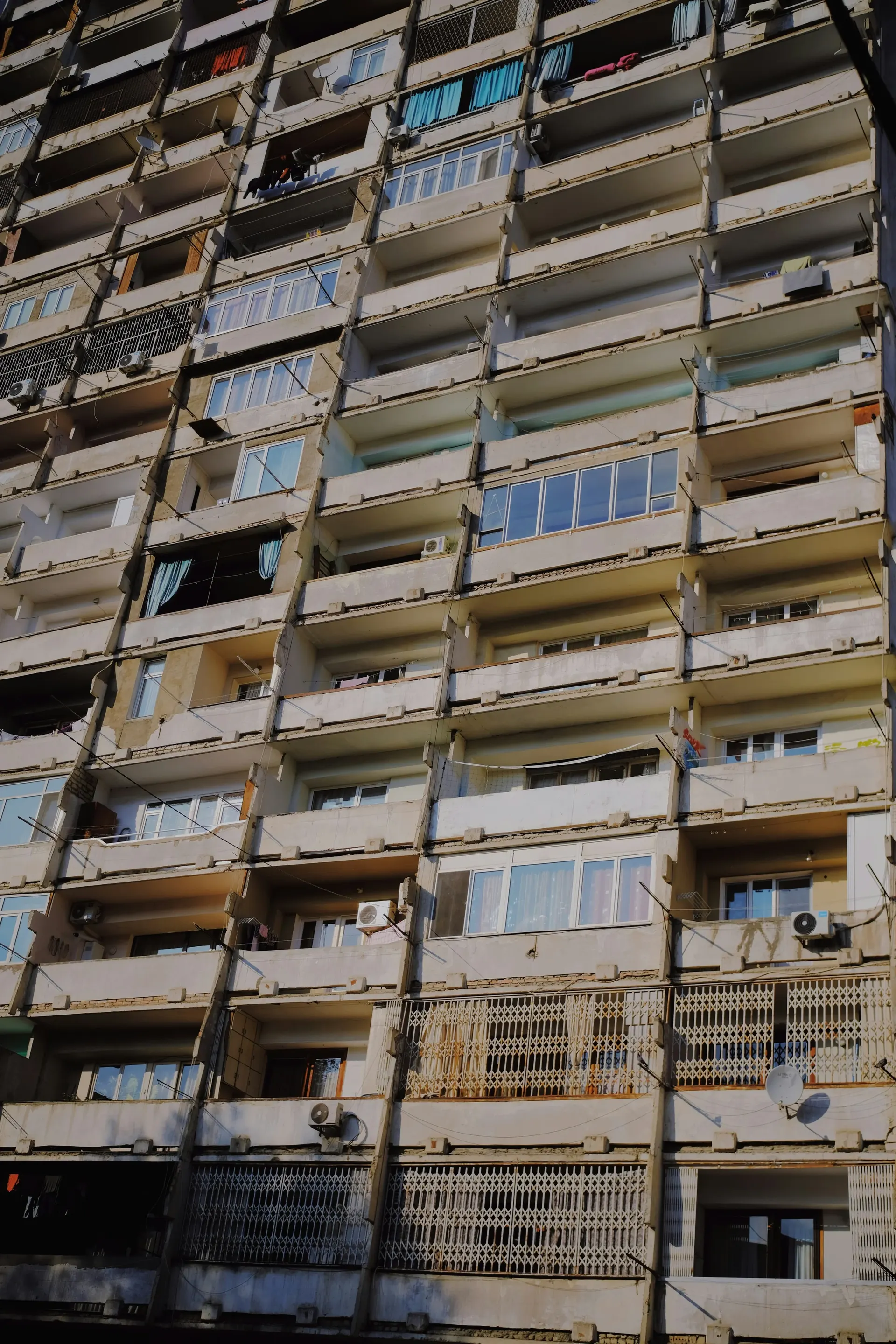 Soviet-era apartment building in Tbilisi with balconies and satellite dishes